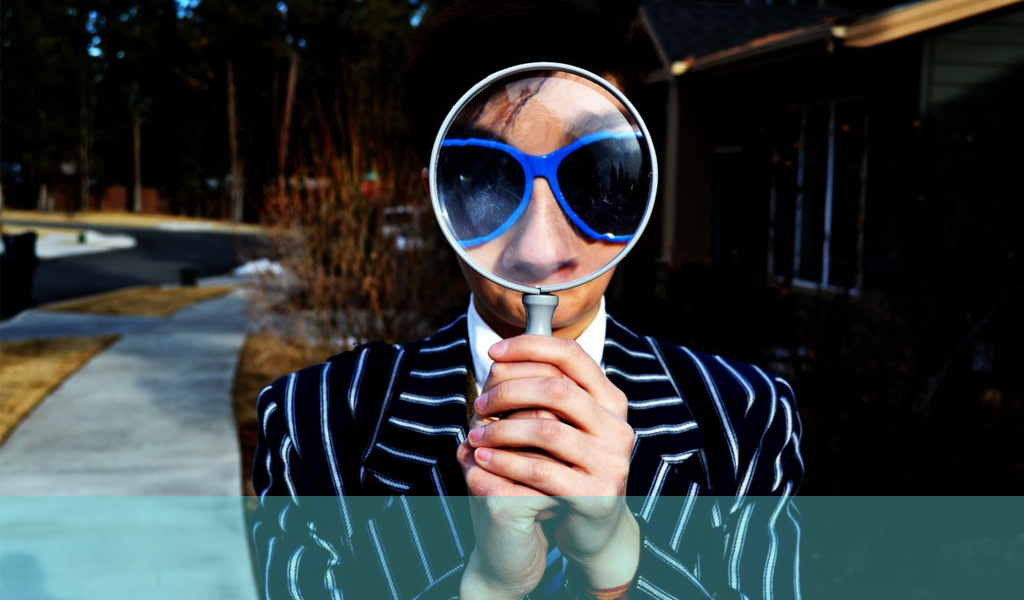 man with a magnifying glass in a loud suit
