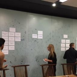 photo of stakeholders using a large board and post it notes