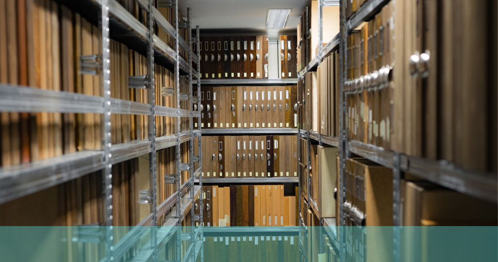 foto de una gran sala de archivo con pilas y estanterías cargadas de expedientes y carpetas