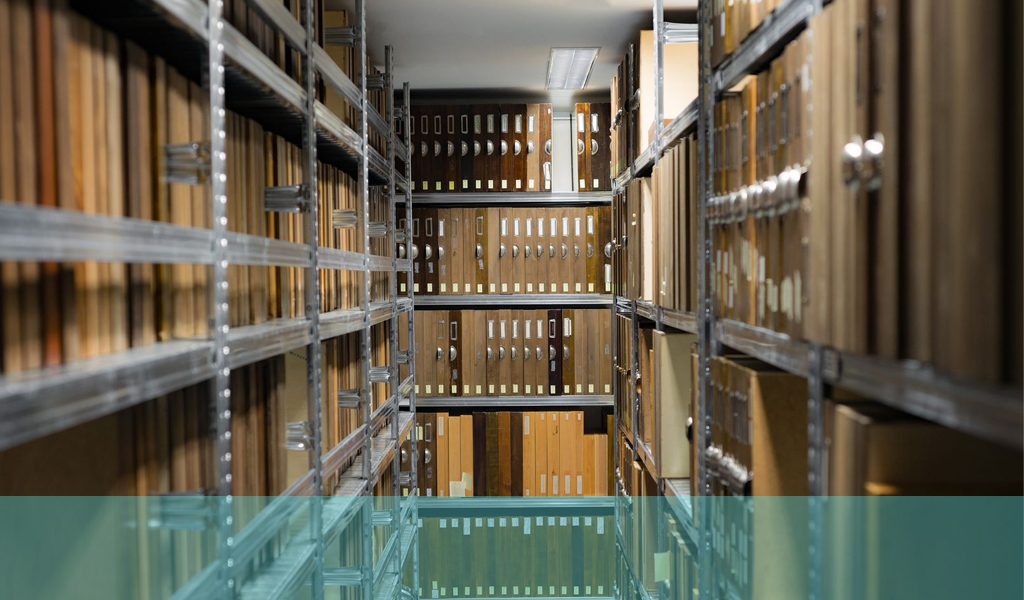 Foto de uma grande sala de arquivos com pilhas e prateleiras cheias de arquivos e pastas